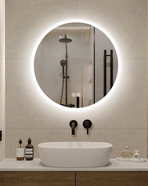 Modern bathroom with round illuminated mirror, sink, and toiletries.