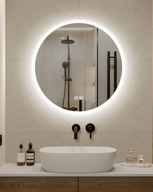 Modern bathroom with round illuminated mirror, sink, and toiletries.